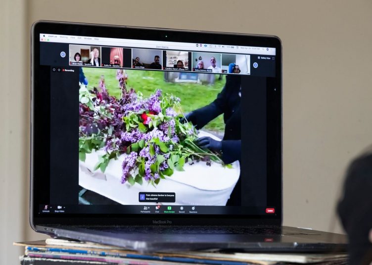 A laptop streaming a funeral over Zoom.