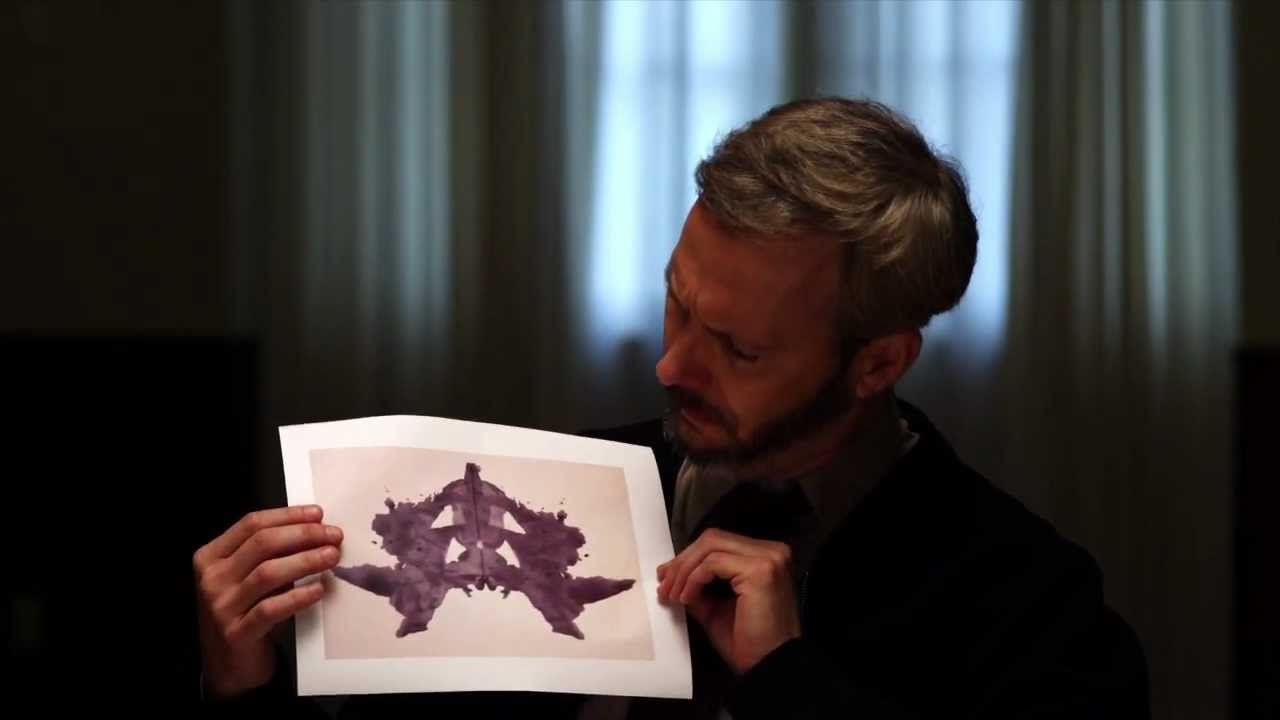 man holding an inkblot page