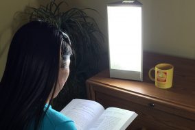 Woman reading by sun lamp