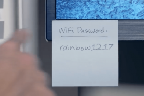 A sticky note stuck to a computer reading "Wifi Password: rainbow1217"