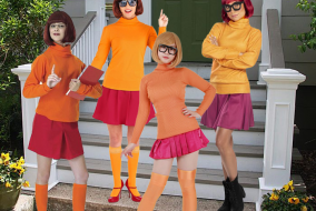 Four women in Velma costumes edited to be standing on porch