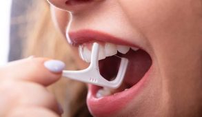 A woman flossing her teeth.