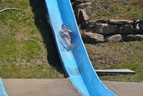 A man with his arms crossed on a waterslide.