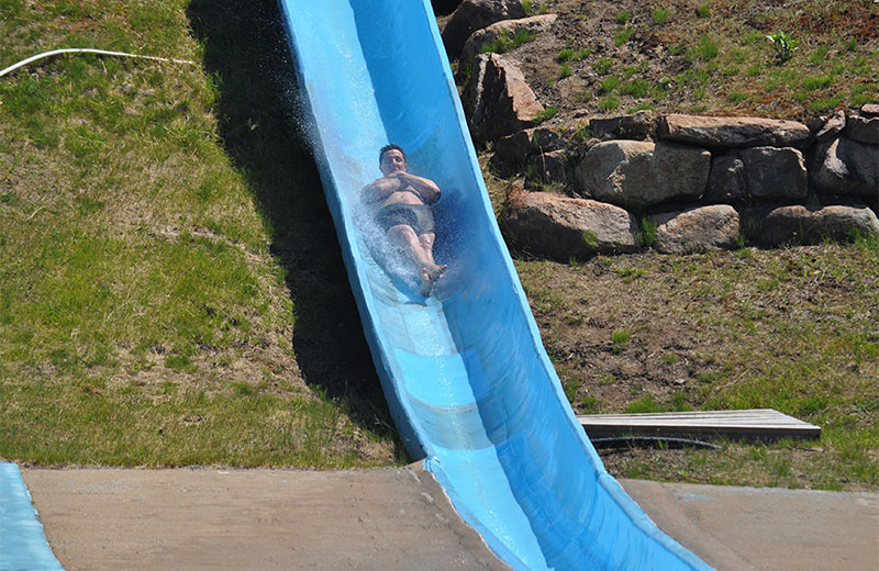 A man with his arms crossed on a waterslide.