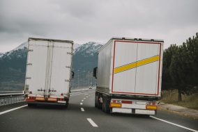 Two trucks driving next to each other in a friendly way