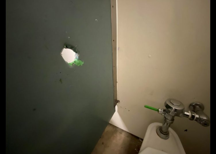 Hole on bathroom stall wall