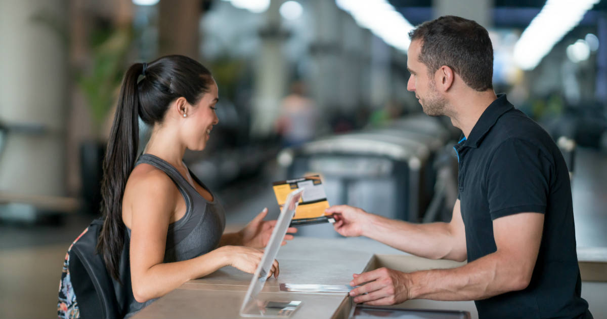 Man standing at counter swiping card for patron