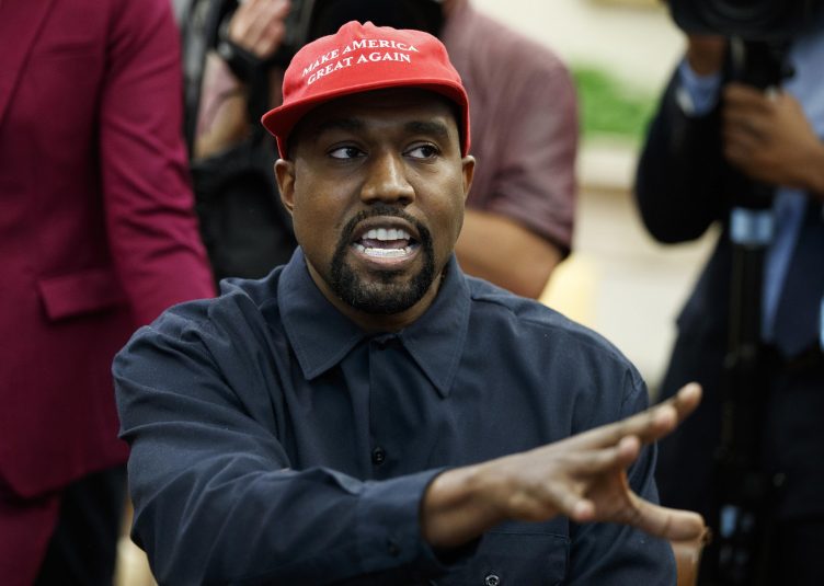 Kanye West wearing a red "Make America Great Again" hat