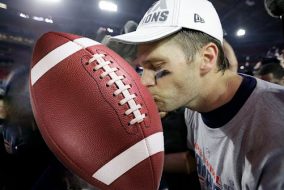 Tom Brady kissing a football