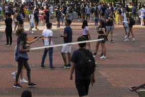 Solicitors pointing a BB gun and a metal prod at students in the Diag.
