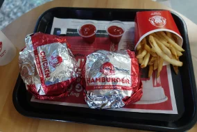 A carton of fries, two cups of ketchup, and two Wendy's burgers sit on a tray.