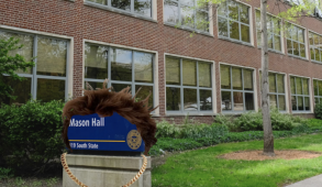 The Mason Hall sign with fluffy brown hair wearing a chain.