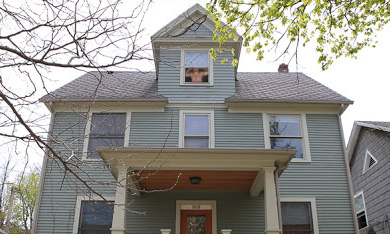 house with shirtless man in upper-floor window