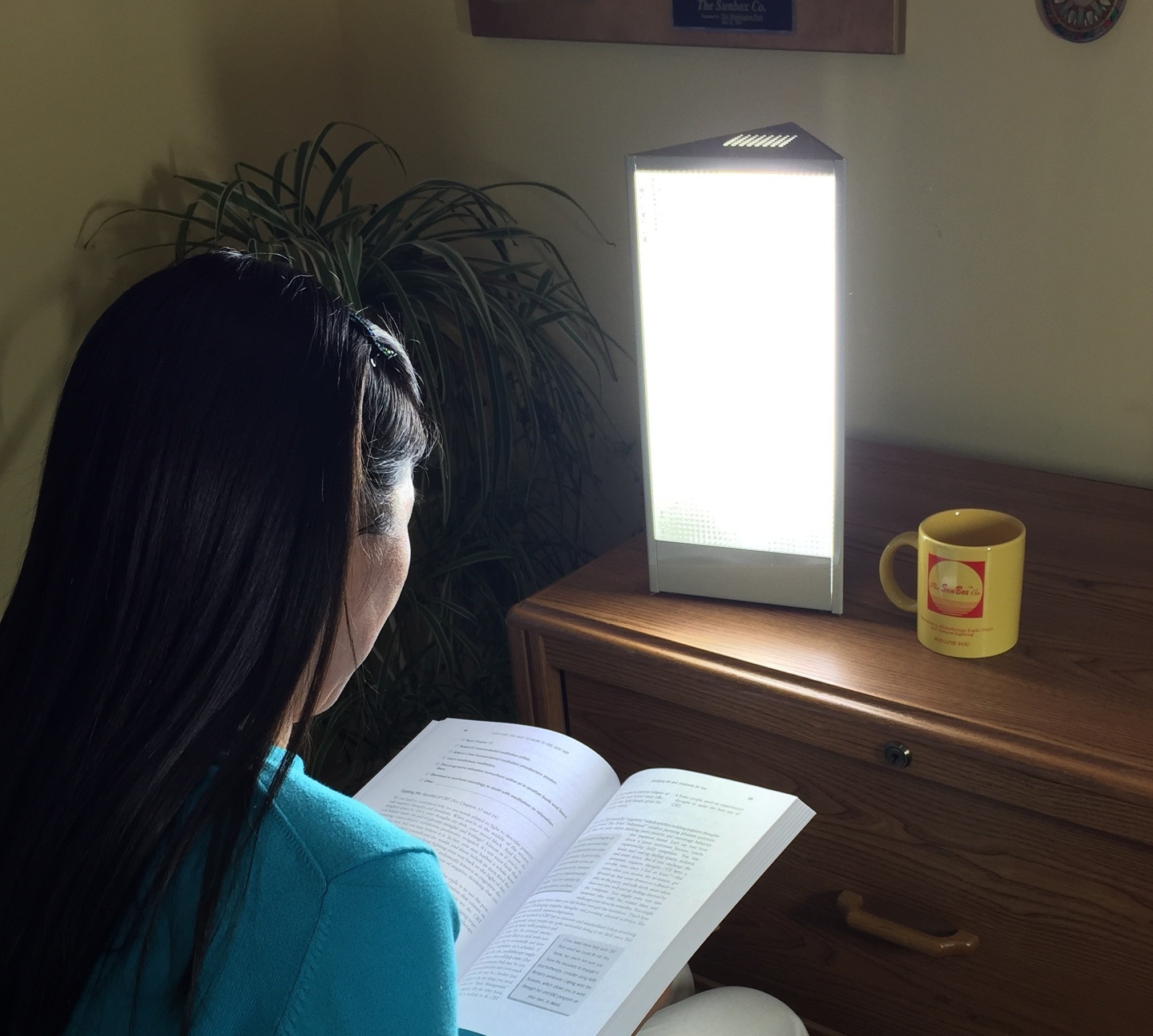 Woman reading by sun lamp