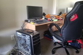 An expensive gaming chair at an unseemly messy desk