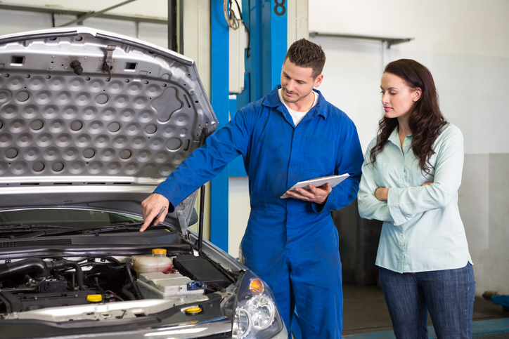 Mechanic showing female customer the problem with her car