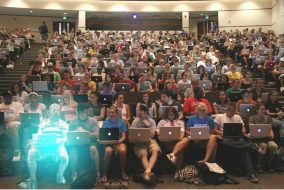 Photoshopped holographic student sitting in lecture hall among many real students