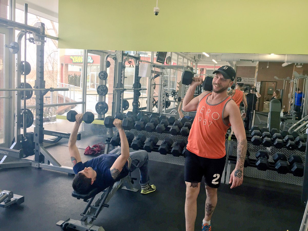 Two men lifting weights in gym and one man is really excited