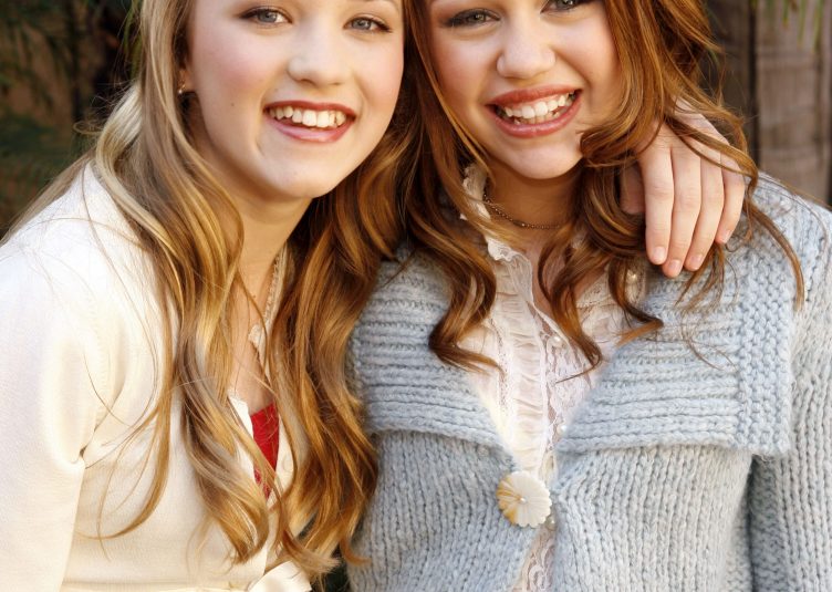 Miley Cyrus and Emily Osment posing together as friends