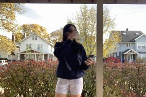 Woman dressed in dark sweatshirt and white, mid-length shorts
