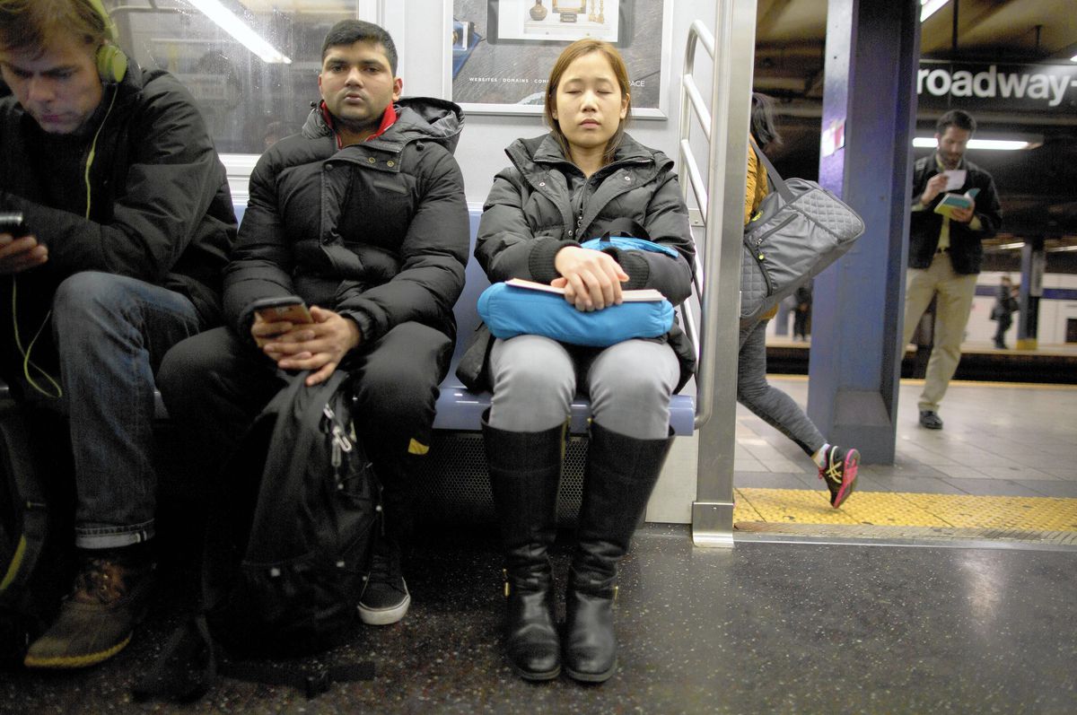 Two people sitting next to each other on a subway