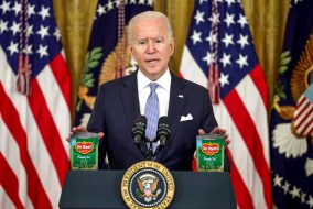 President Biden standing at a podium with several cans of green beans