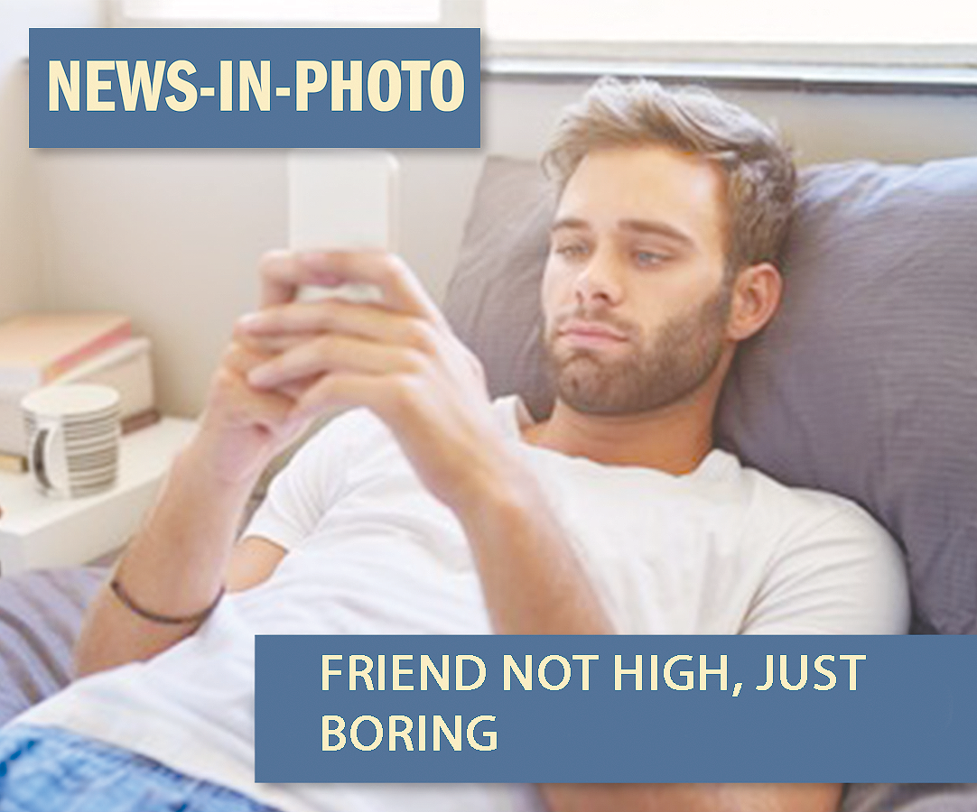 A man sitting on the couch on his phone.