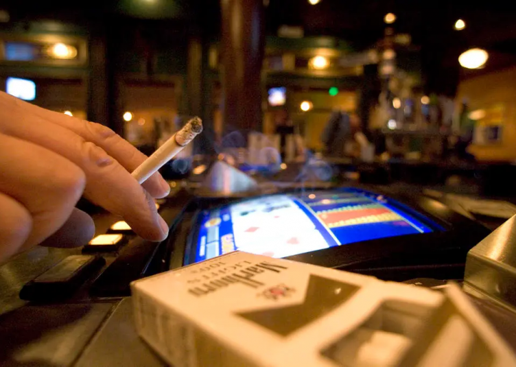 A man gambling with a pack of cigarettes.