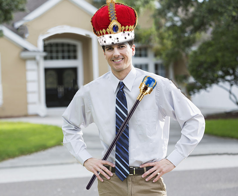 Landlord standing in front of his house wearing a crown and holding a scepter.