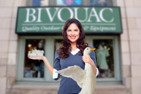 A woman holding a freshly-plucked Canada Goose in front of Bivouac