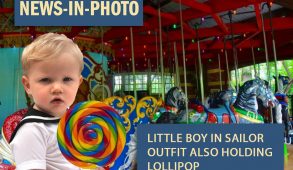 little boy in sailor outfit holding lollipop