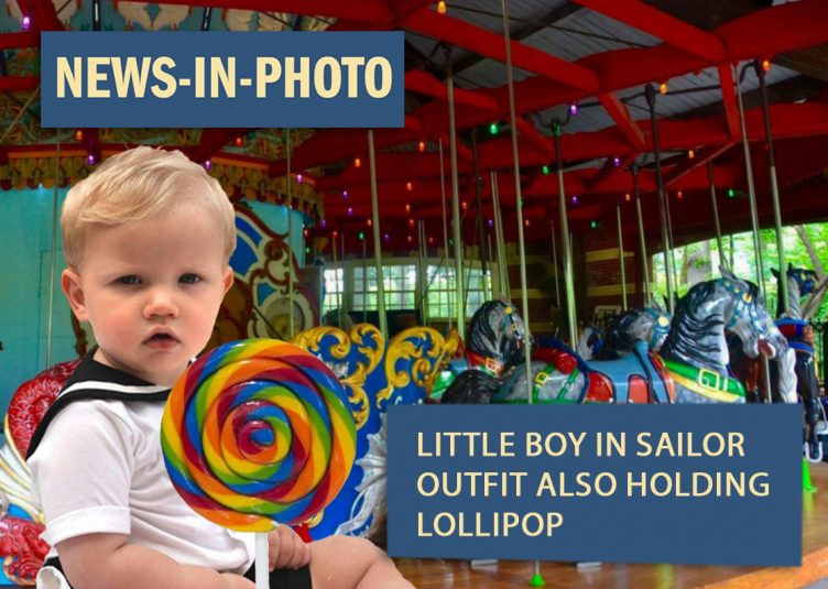 little boy in sailor outfit holding lollipop