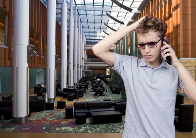 Photoshopped man in frustrated, on the phone in University of Michigan Ross School of Business' interior