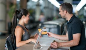 Man standing at counter swiping card for patron