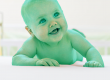 A smiling, green-tinted baby