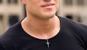 Close-up of a cross necklace worn by a man in a black t-shirt.