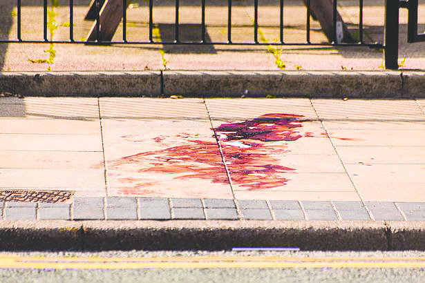 A sidewalk with splattered blood on spilt