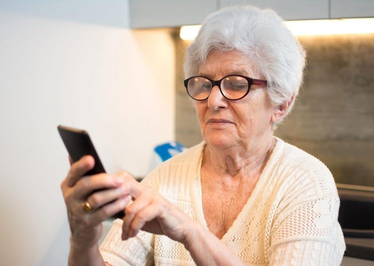 A grandma using a cell phone.