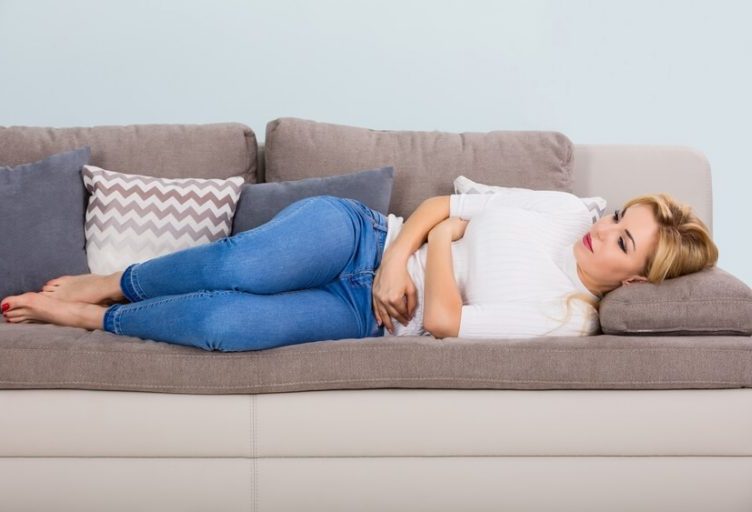 A woman laying down on a couch.