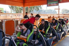 Ride attendant strapping riders into rollercoaster