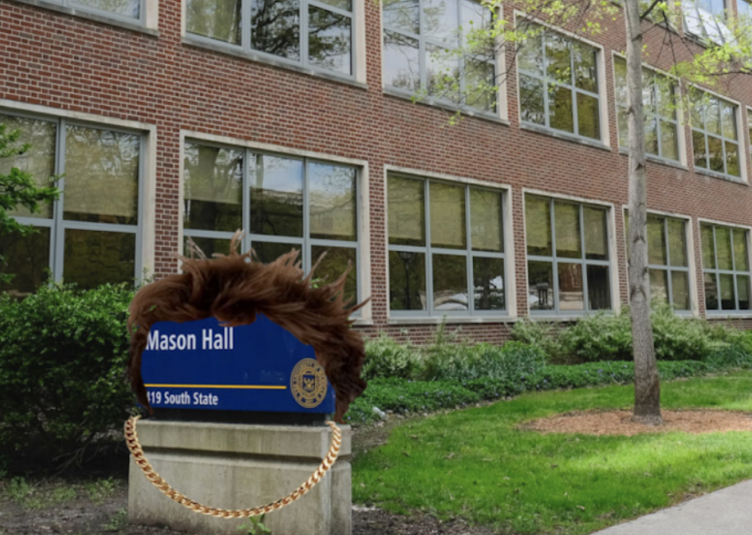 The Mason Hall sign with fluffy brown hair wearing a chain.