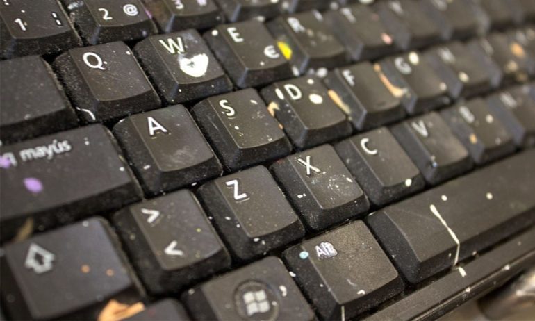A laptop keyboard covered in crumbs.
