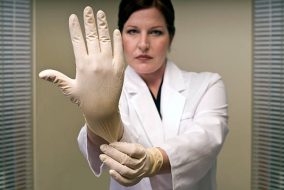 A prostate examiner flexing a gloved hand